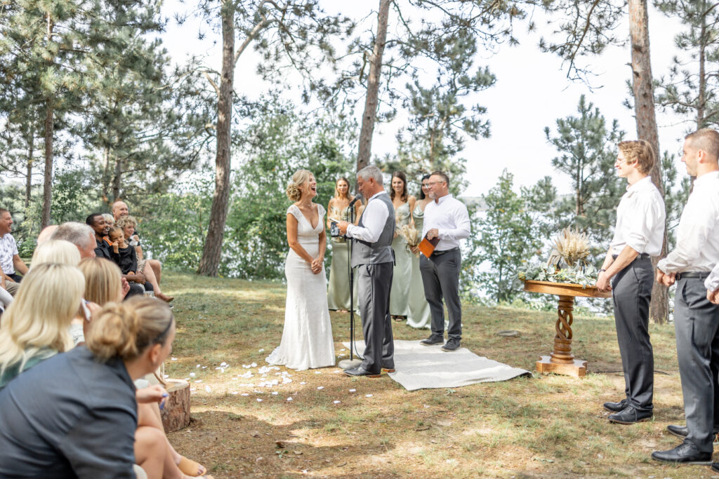 The bride and groom laughing as they say their vows and are photographed by the Brainerd wedding photographer